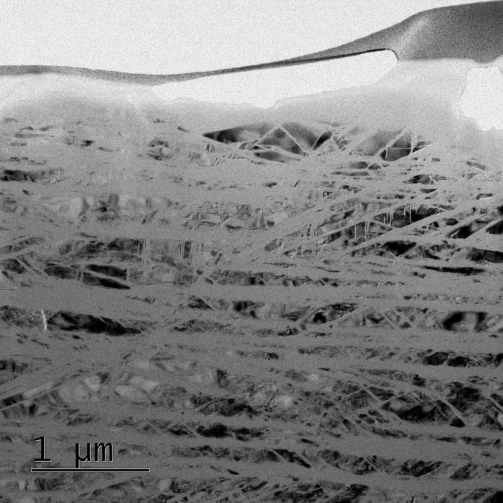In einem Quarzkristall entstehen durch simulierte Asteroideneinschläge winzige, nur einige Dutzend Nanometer breite Glaslamellen, die erst unter dem Elektronenmikroskop sichtbar werden.