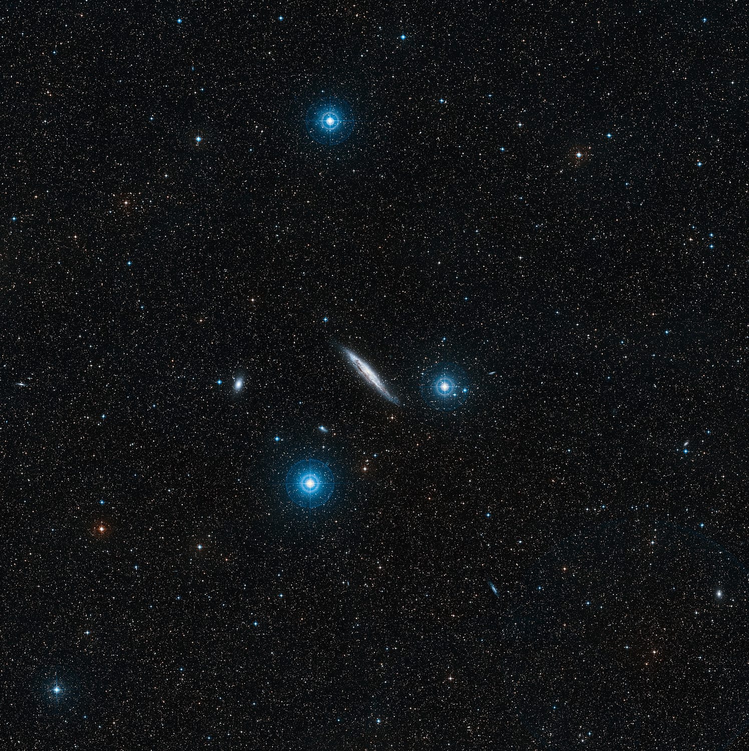 Die Spiralgalaxie NGC 4945 liegt zwischen drei Sternen der 4. Helligkeitsklasse, die mit bloßen Augen sichtbar sind
